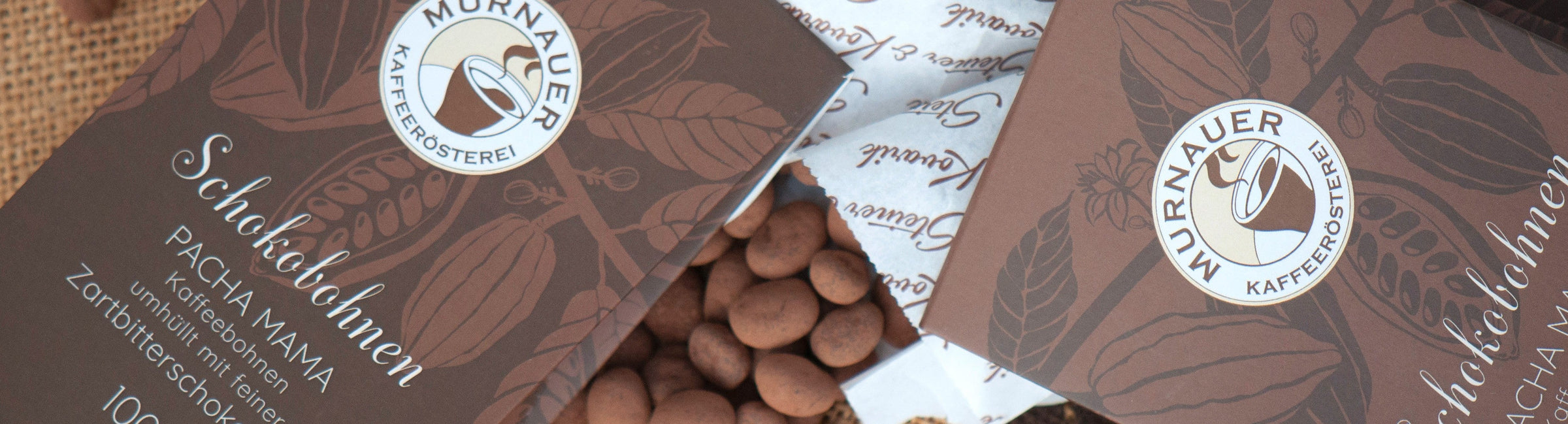Braune Verpackungen Schokobohnen Pacha Mama der Murnauer Kaffeerösterei, geöffnete Packung mit dragierten Bohnen