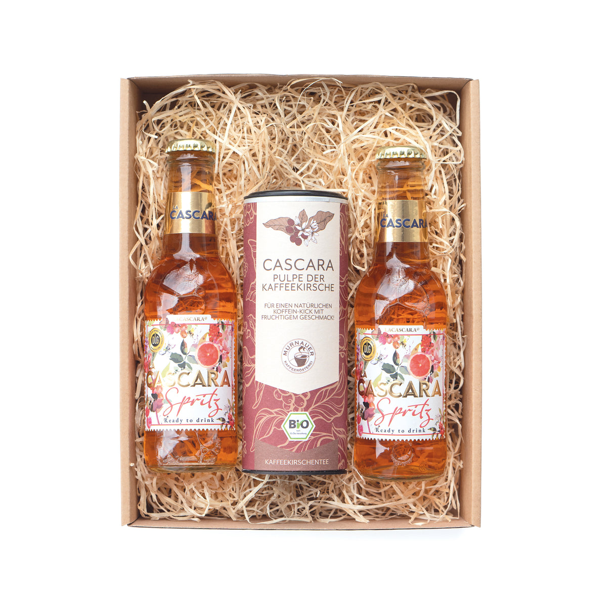 Geschenkset mit zwei Cascara Spritz Flaschen und Dose Cascara Kaffeekirschen-Tee im Karton mit Holzwolle, frontal