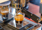 Barista-Kurs: Espresso & Latte Art, Espresso läuft aus Siebträger in Glas auf Waage unter Siebträgermaschine beim Barista Kurs der Murnauer Kaffeerösterei