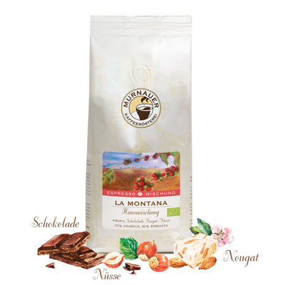 Weiße Kaffeepackung La Montana Hausmischung der Murnauer Kaffeeroesterei mit Schokolade, Nüssen und Nougat davor