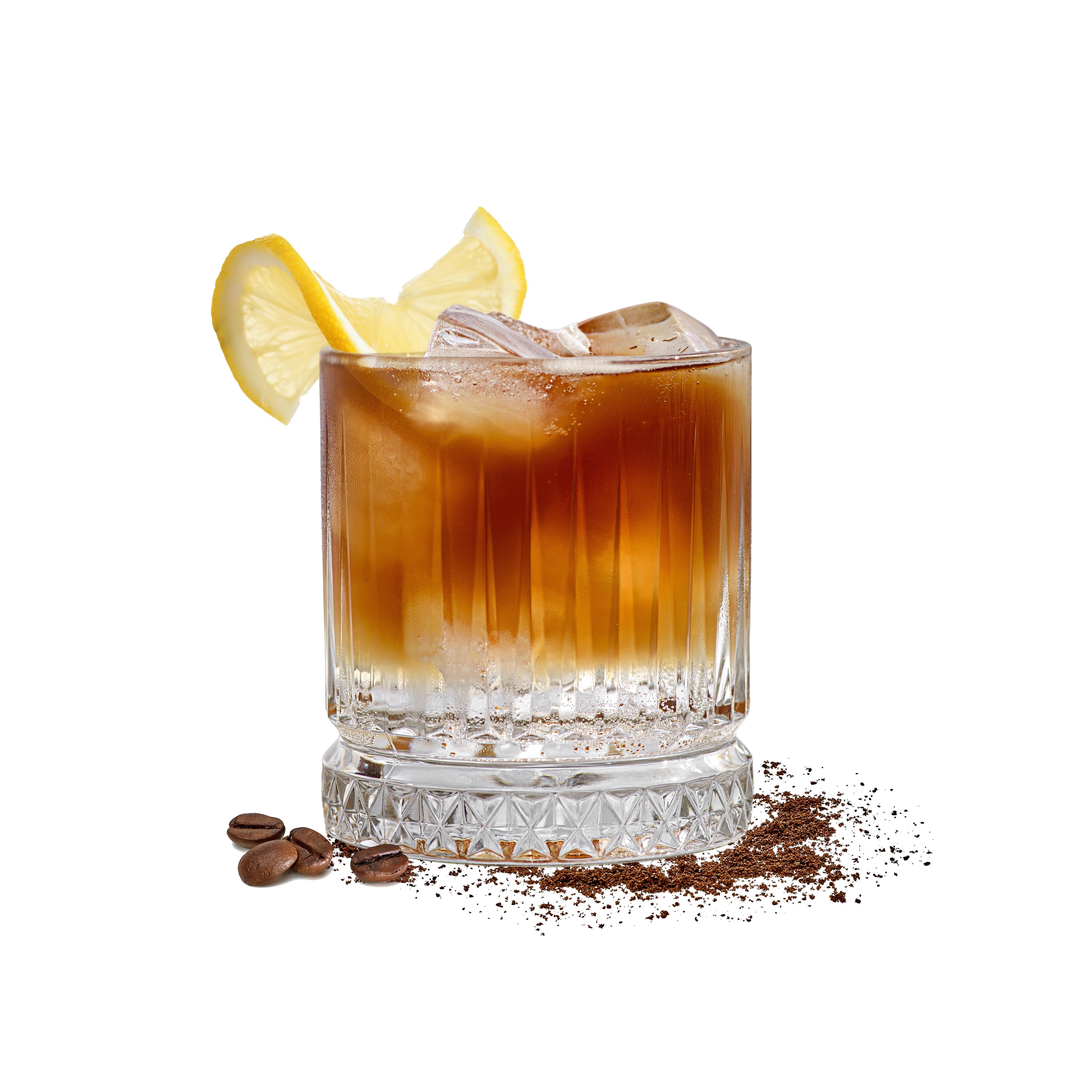 Espresso Tonic im klaren Glas mit Eiswuerfeln, Zitronenscheibe, Kaffeebohnen und Kaffeepulver auf weissem Hintergrund