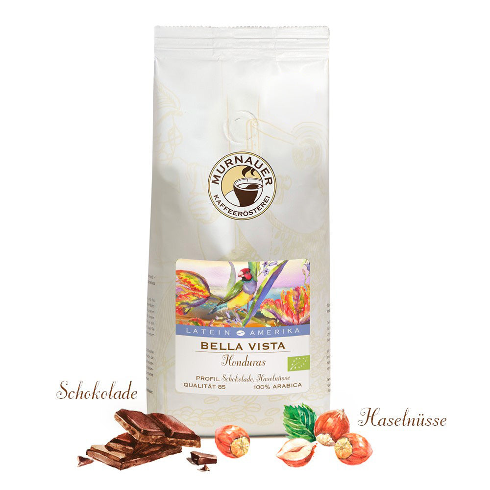 Weiße Kaffeepackung Bella Vista Honduras der Murnauer Kaffeeroesterei mit Schokolade und Haselnüssen davor