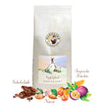 Weiße Kaffeepackung Gipfelglück Kaffeelust der Murnauer Kaffeerösterei, davor Schokolade, Nüsse und tropische Früchte als Aromen