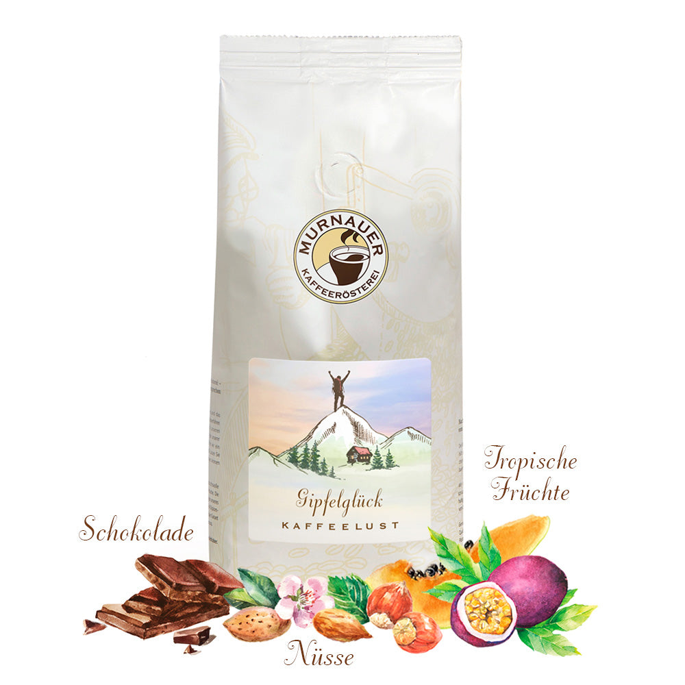 Weiße Kaffeepackung Gipfelglück Kaffeelust der Murnauer Kaffeerösterei, davor Schokolade, Nüsse und tropische Früchte als Aromen