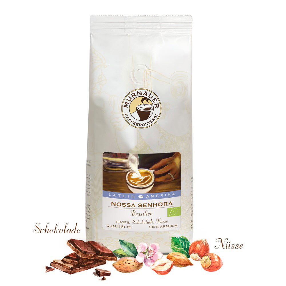 Weiße Kaffeepackung Nossa Senhora Brasilien der Murnauer Kaffeerösterei mit Stückchen Schokolade, Nüssen und Bio-Siegel im Vordergrund