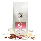 Weiße Kaffeepackung Best Cup 3 Pacha Mama der Murnauer Kaffeerösterei mit Schokoladenstücken, Sahne, Vanilleschoten und Kirschen als Aromensymbole vor weißem Hintergrund, Spezialitätenkaffee aus Peru