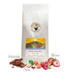 Weiße Kaffeepackung San Miguel Guatemala der Murnauer Kaffeeroesterei mit Schokolade, Nüssen und Beeren davor