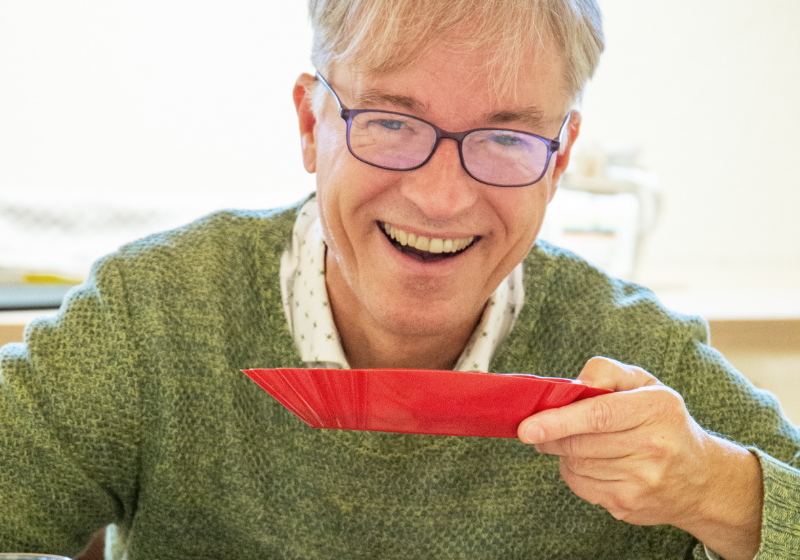 SCA-Trainer Michael Eckel im Kaffeegeheimnis Kurs der Murnauer Kaffeerösterei riecht lächelnd an roter Duftschale, Kaffee-Akademy im Murnauer Kaffeehaus