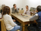Kaffeerösten Kurs mit Inhaber Thomas Eckel in der Kaffee Academy im Murnauer Kaffeehaus, erklärt Anbau und Röstung an Bild vor Teilnehmern