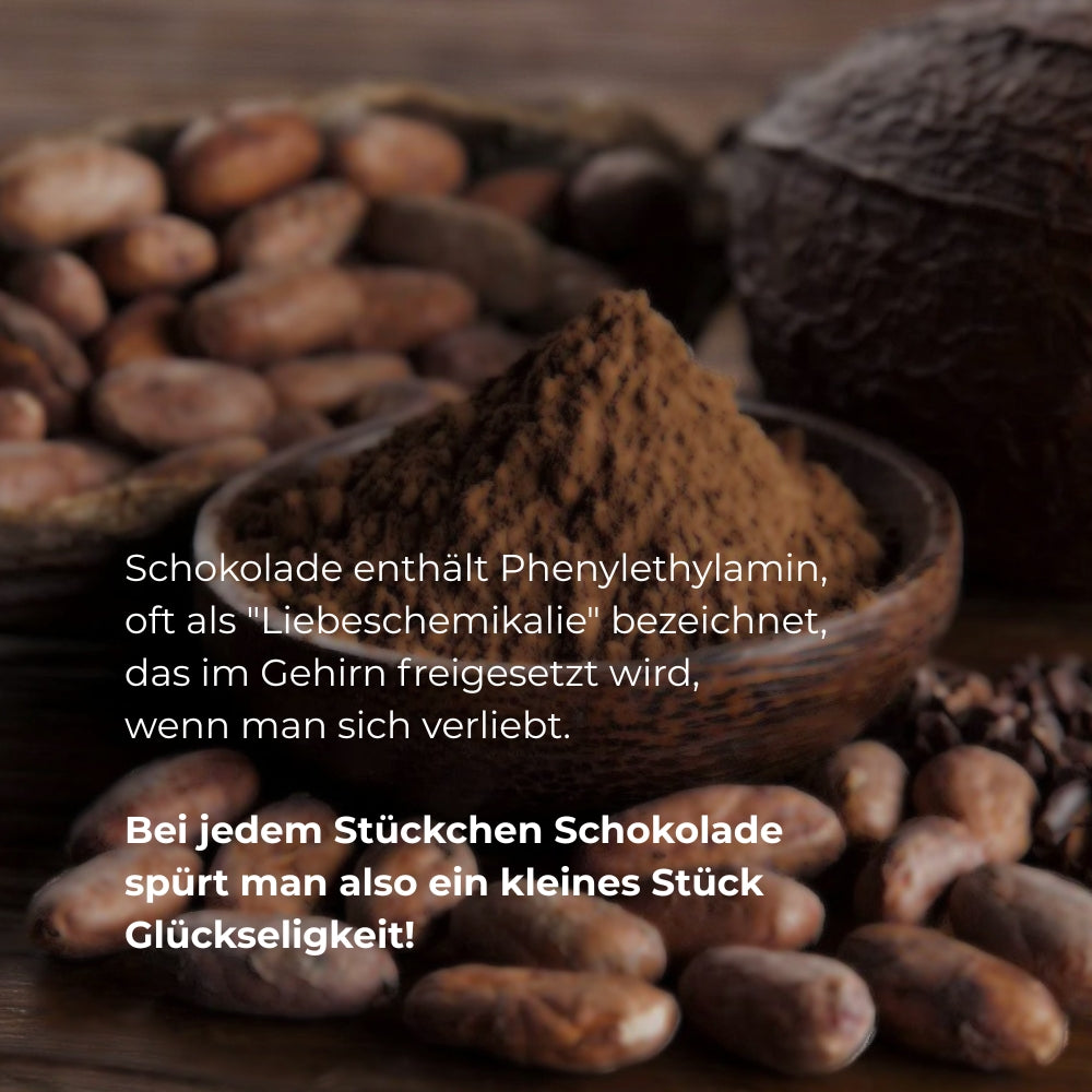 Murnauer Kaffeerösterei: Kakaobohnen und ein Häufchen Kakaopulver in einer Holzschale, Moodbild für Trinkschokolade