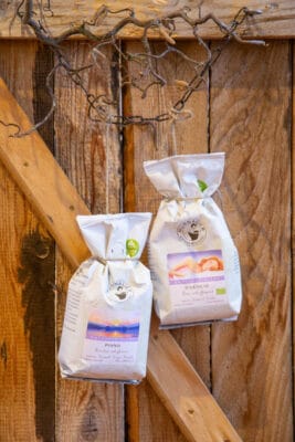 DeCaf - entkoffeinierter Kaffee - Wie gesund? Zwei DeCaf Kaffetüten vor einer Holzwand