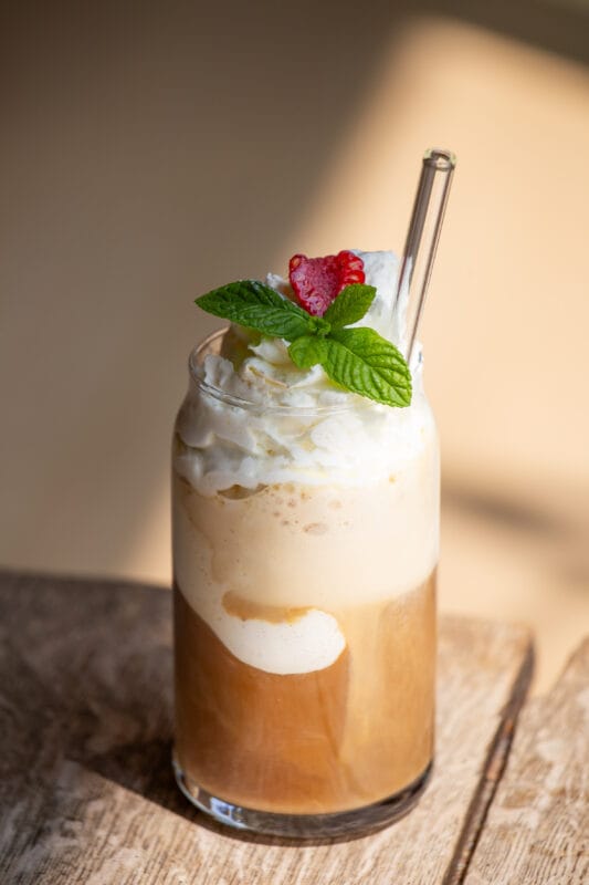 Erfrischender Eiskaffee mit Cold Brew, Vanilleeis und Sahne im Glas – garniert mit frischer Minze und Himbeere. Sommerliches Kaffeerezept, ideal für heiße Tage und perfekt für Cold Brew Liebhaber.