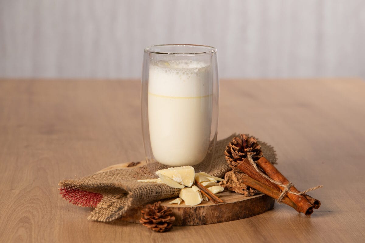 Weiße Winterschokolade in einem hohen Longdrink Glas und Deko