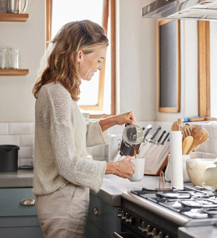 Kaffee-Adventskalender 2 Kaffee-Adventskalender-Frau-steht-in-der-Kueche-und-giesst-frisch-gebruehten-Kaffee-in-eine-Tasse