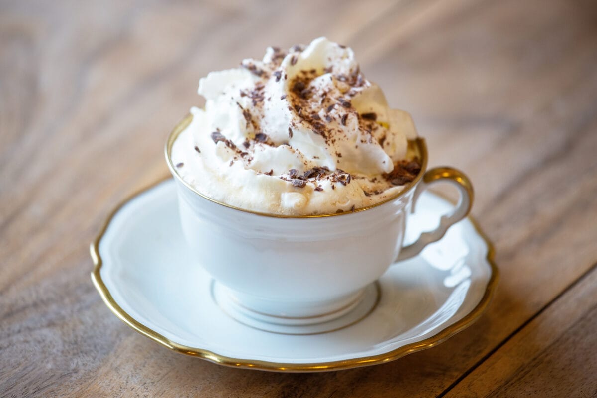 Pharisäer Kaffee mit Sahnehaube und Schokoladenraspeln in Tasse mit Unterteller serviert