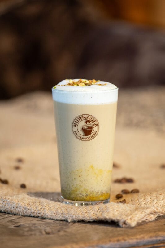 Pistazien Latte 1 Pistazien Latte - Kaffeekreation fertig zubereitet auf einem Tisch - 2